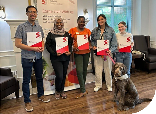 PSW worker is talking and smiling with old couple at the dining table